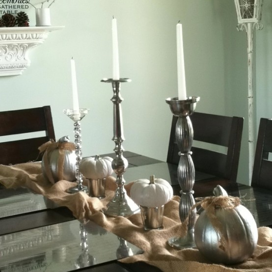 a burlap runner, silver buckets and candleholders, white candles, white and silver pumpkins for a refined vintage Thanksgiving tablescape