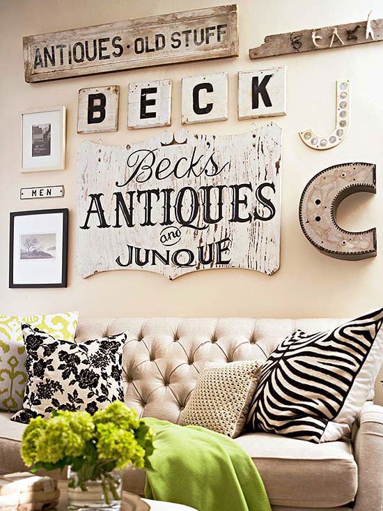 a neutral vintage living room with a neutral sofa and some printed pillows, a vintage gallery wall and some greenery is a chic and cool space