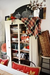 a neutral rustic buffet with bright velvet pumpkins and a plaid blanket on top is a lovely idea to realize for fall or Thanksgiving