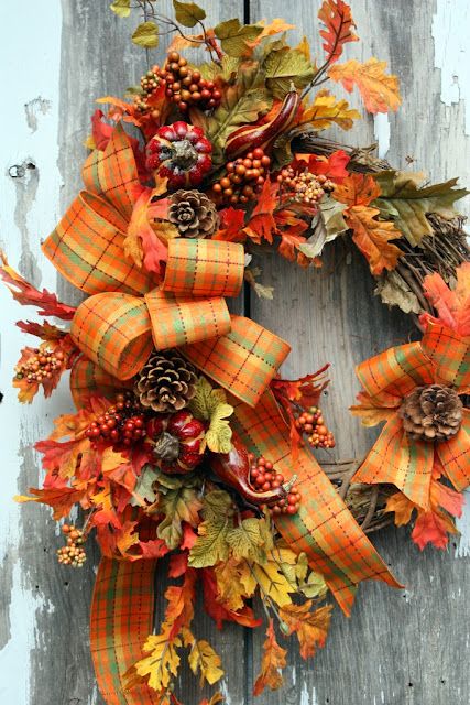 a fall or Thanksgiving wreath of faux gourds and pumpkins, berries and pinecones, faux leaves and plaid ribbons is a cool idea