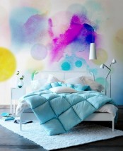 a bright watercolor accent wall behind the headboard, with a white bed, with turquoise bedding, a small white nightstand and a white floor lamp is a catchy and cool idea