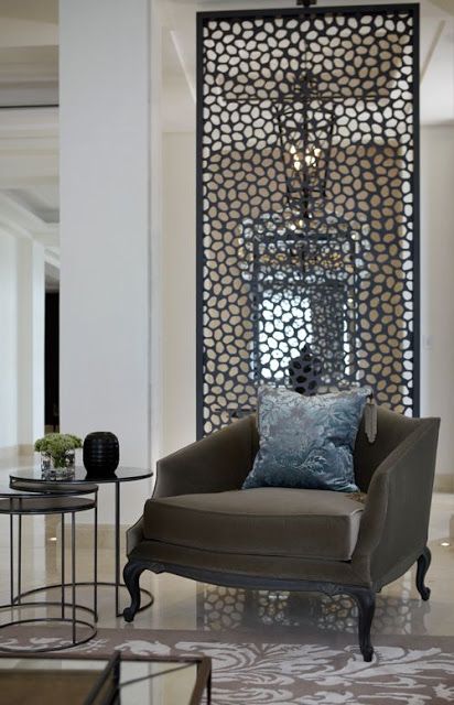 a chic nook with a catchy mirror wall, an antique brown chair, a duo of side tables
