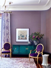 a sophisticated purple living room with lilac curtains, gorgeous antique purple and gold chairs and an emerald credenza