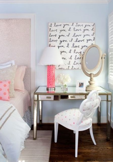 a pastel glam bedroom with a blush bed with blush bedding, a mirror desk that is a nightstand, an antique white chair renovated with polka dot fabric