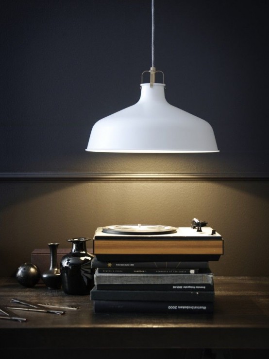 a vinyl nook with a stack of vintage books and a white Ranarp pendant lamp over the space that highlights the style