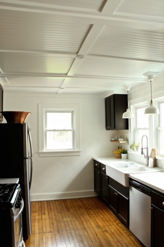 a stylish black and white kitchen with white IKEA Ranarp pendant lamps is a stylish and cool space, and the lamps highlight the slightly vintage feel of the kitchen