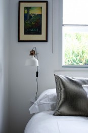 a lovely IKEA Ranarp sconce perfectly matches this Nordic bedroom with a vintage feel
