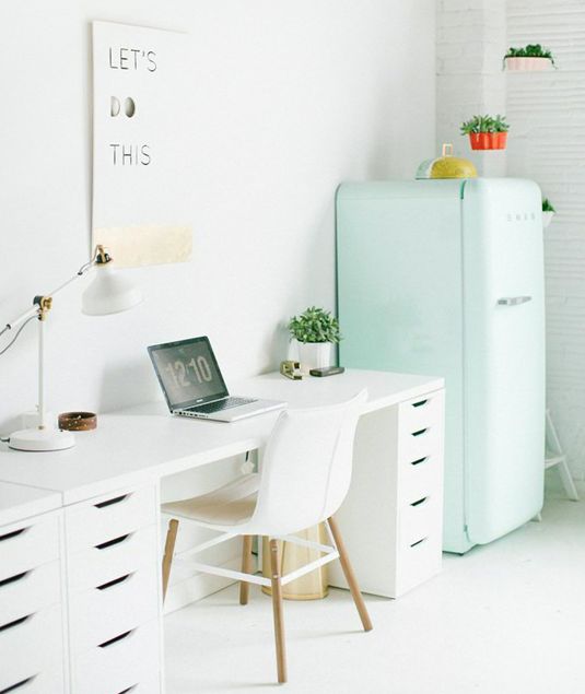 a Scandinavian work space finished with a white IKEA Ranarp table lamp that matches the space and a mint fridge that brings color
