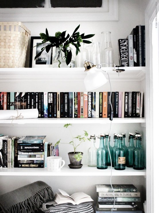 open shelves with greenery in a vase, potted plants, a little Ranarp lamp with a clothespin, which allows moving it wherever you need