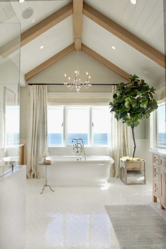 a seaside bathroom in neutrals, with wooden beams, built-in lights, a tub, a shower space and windows for a view