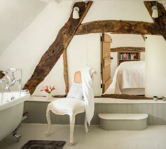 a vintage bathroom with grey paneling, wooden beams on the wall, a vintage tub and vintage fixtures