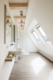 a modern white bathroom with windows, a floating vanity, a large mirror and wooden beams on the ceiling