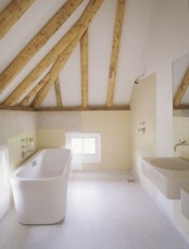 a neutral bathroom with a tile floor, warm colored walls, wooden beams and a free-standing tub