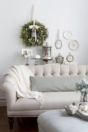 a fresh greenery wreath and a greenery arrangement on the table enliven the living room and make it fresh