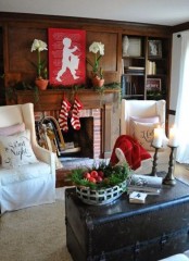 a living room spruced up with holiday reds, evergreens and white blooms to refresh it and make it feel festive