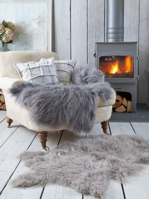 a vintage-inspired metal hearth with a chair by it and some faux fur is the greatest nook to spend some time