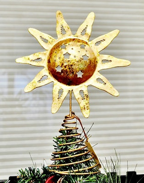 an oversized gold sun with stars tree topper is a shiny and glam Christmas tree accessory that will make a statement