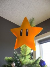 a fun and bright yellow star tree topper is a bold and colorful decor touch and it screams about your love to video games