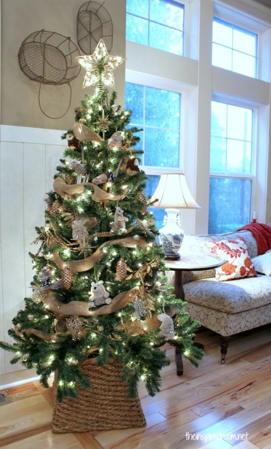 a shiny rustic Christmas tree decorated with burlap ribbons, faux animal figurines, a lit up star tree topper that adds shine to it