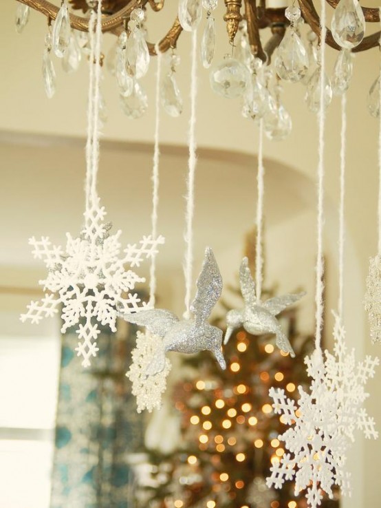 white snowflakes and silver glitter birds hanging from the chandelier are great and easy decoration for Christmas