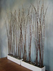 white planters with pebbles and tall willow are a cool decoration for spring – indoor or outdoor