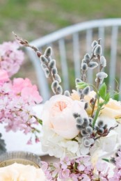 a spring centerpiece of willow, pink and white blooms looks bright, cheerful and fun