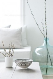 some willow in a mug and in a large glass bottle on the floor will make your living room feel like spring