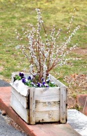 a wooden box with greenery, bright blooms and willow is a cool outdoor decoration for spring