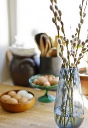 a blue clear vase with some willow is a simple and cute modern centerpiece for spring and Easter