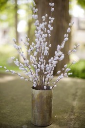 a rough metal vase with willow is a cute decoration or centerpiece for a modern or rustic spring home