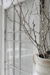 a vintage white jug with whitewashed branches and willow is a natural and fresh sprign decoration you can easily make