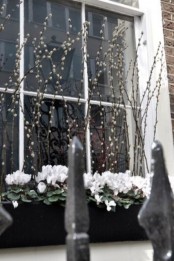 window boxes with white blooms and willow is a cool idea to style your home for spring outdoors