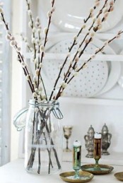 a clear jar with pussy willow branches is a delicate home decoration for spring