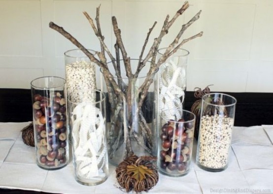 natural fall decor with clear vases filled with nuts, acorns, branches and some vine pumpkins