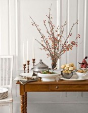an arrangement of branches with bright red berries as a fall decoration or a centerpiece