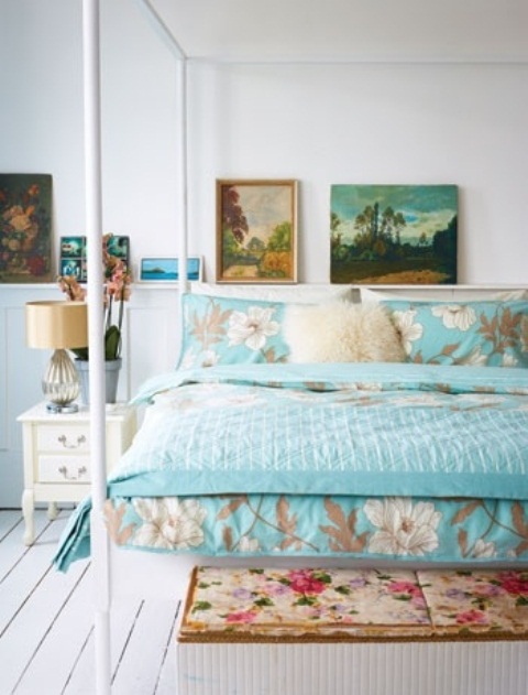 bright and colorful bedding, bright artworks and a floral bench make the neutral bedroom feel more spring-like