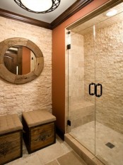 a chic neutral bathroom with a rough stone floor and walls and some decorative stone added