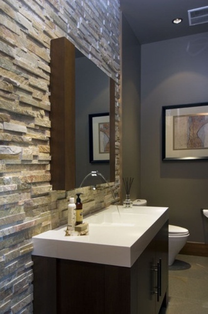a modern bathroom with an accent wall done with decorative stone for a textural and chic look