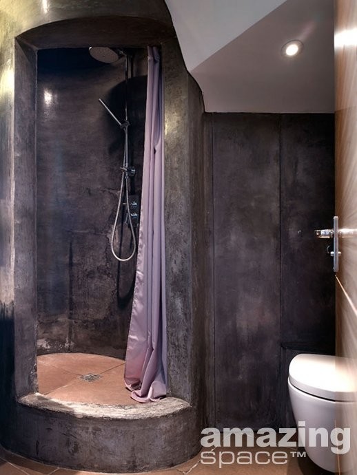 a wabi-sabi bathroom with stone walls and a shower space plus tiles all over for a contrasting look