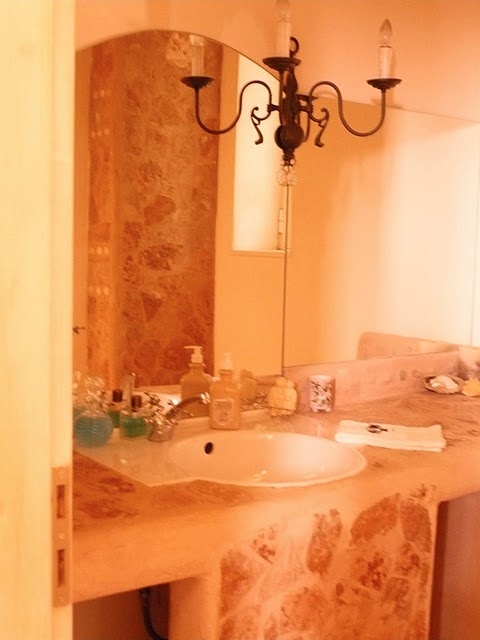 a neutral bathroom done with rough stone and light-colored wood looks chic and welcoming