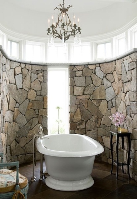 a gorgeous bathroom clad with stone, with a chic crystal chandelier, refined furniture and blooms a gorgeous bathroom clad with stone, with a chic crystal chandelier, refined furniture and blooms
