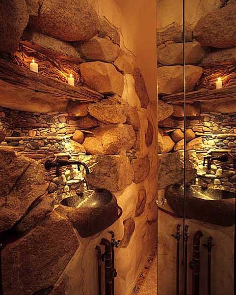 a wabi-sabi bathroom with stone walls, a stone sink and built-in lights for accenting