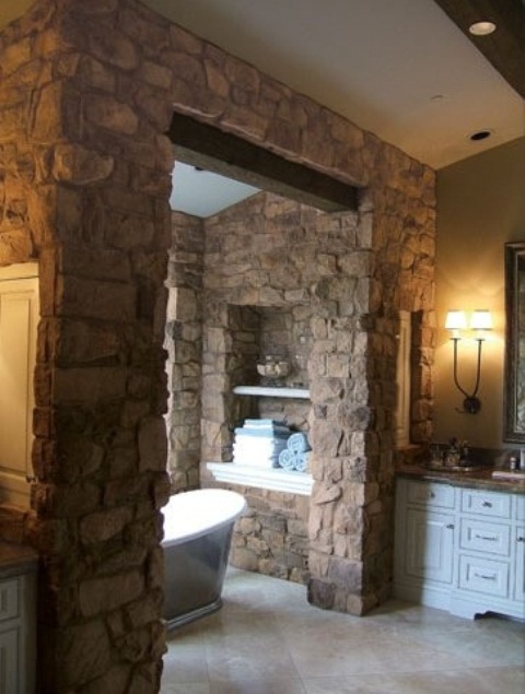 a bathroom with a bathtub space all clad with natural stone to separate and highlight this zone as much as possible