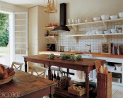 a beautiful vintage farmhouse kitchen with open cabinetry, open shelves instead of upper ones, a vintage stained table as a kitchen island