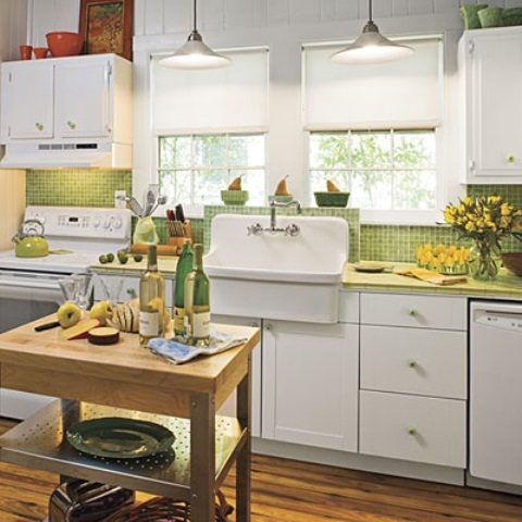 a white kitchen with shaker cabinets, a neon green tile backsplash and countertops plus a small stained table as a kitchen island